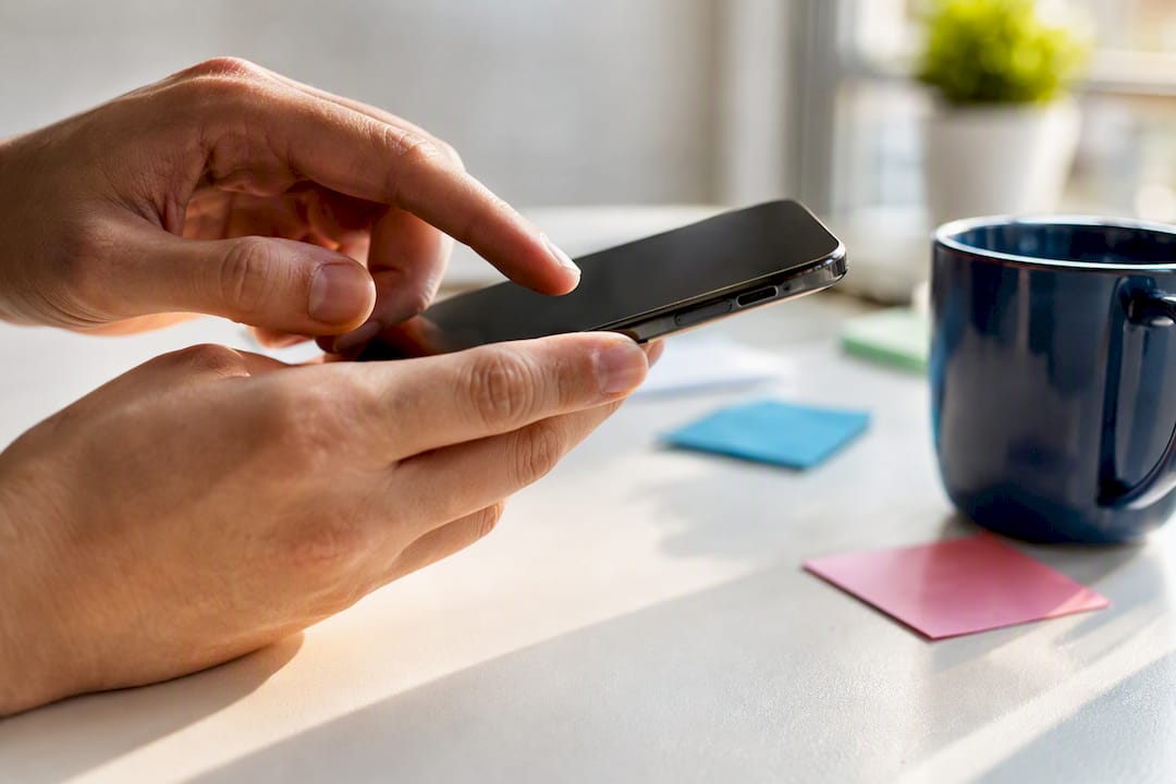 Hand poised above phone symbolizing review requests