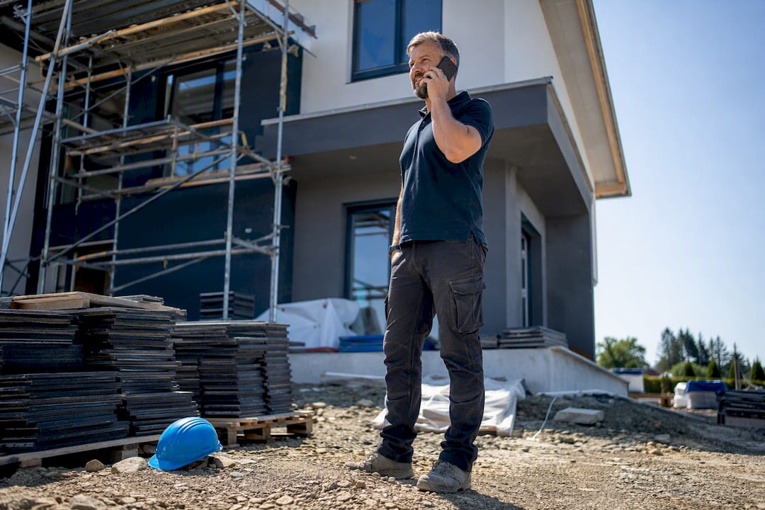 Contractor making call at roofing job site