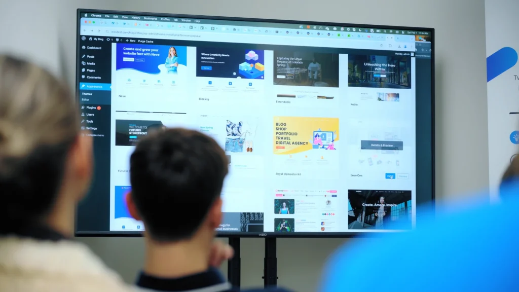 Modern business team reviewing website redesign wireframes on desktop and mobile screens
